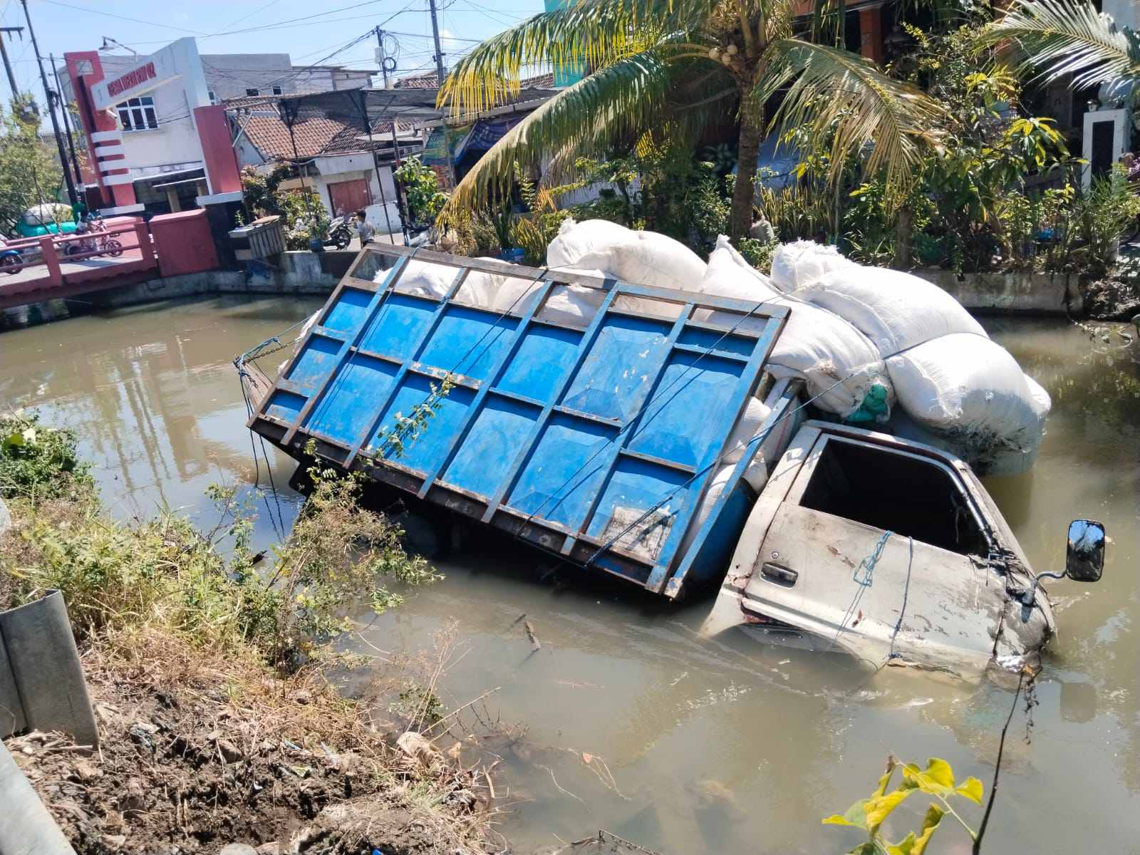 Truk Nyemplung ke Sungai, Plastik Ikut “Mandi”, Sopir Selamat Berkat Aksi Pecah Kaca